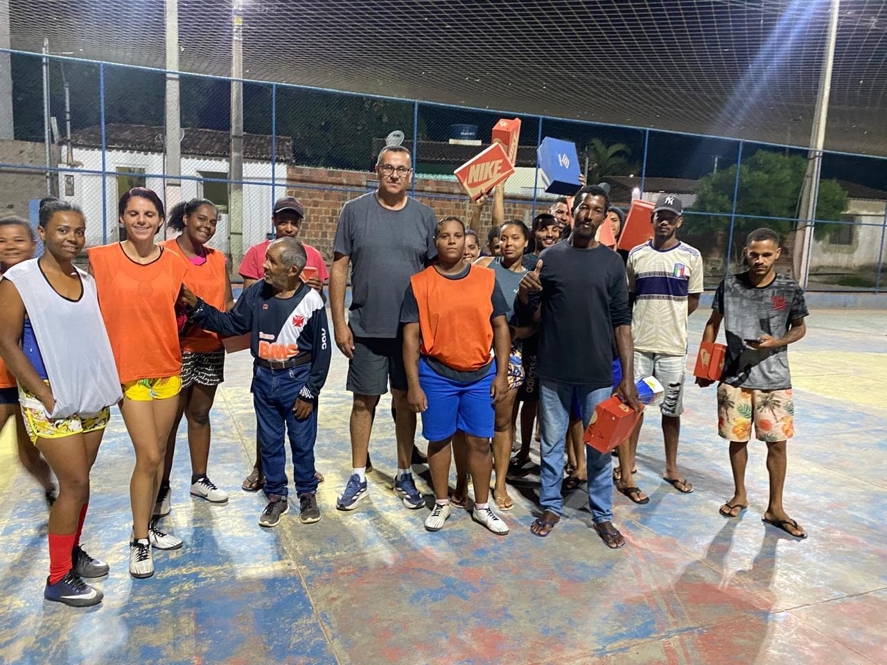 Entrega de chuteiras e materiais esportivos em quadra comunitária